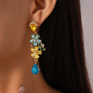Detail of vintage floral drop earrings with colorful crystals and butterflies on model