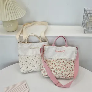 Detailed view of floral canvas tote bags with delicate lace edges on a cream background