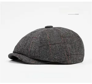 Detail of light gray herringbone tweed newsboy cap with subtle red plaid pattern