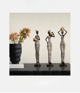 Close-up of three African tribal women figurines in traditional colorful geometric dresses