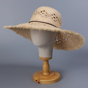 Handwoven straw sun hat for women featuring hollow mesh crown and wide frayed brim