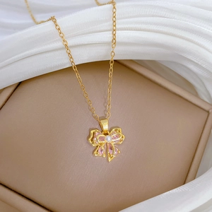 Detail of pink crystal bow necklace with pearls on a gold-plated stainless steel chain