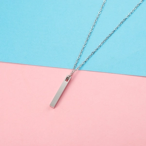 Macro shot of silver 3D pillar pendant on a minimalist stainless steel chain necklace