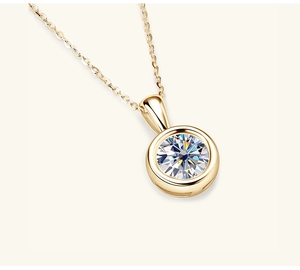 Macro shot of a minimalist gold pendant necklace featuring a round brilliant-cut stone