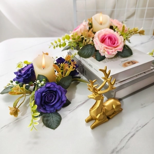 Close-up of artificial rose wreath with LED candle and golden deer figurine decor
