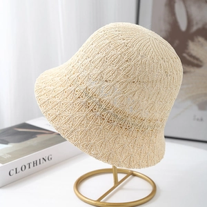 Close-up of beige crochet knit bucket hat with delicate hollow out floral pattern details