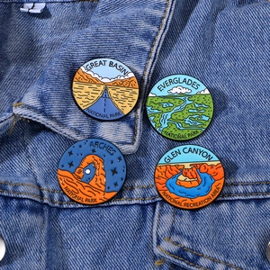 Set di quattro spille smaltate dei parchi nazionali su una giacca di jeans blu