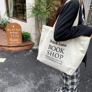 Close-up of beige canvas tote bag with Brick Lane Book Shop print in outdoor setting