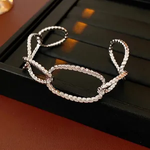 Silver chunky oval link open bangle with textured surface on luxury black leather base