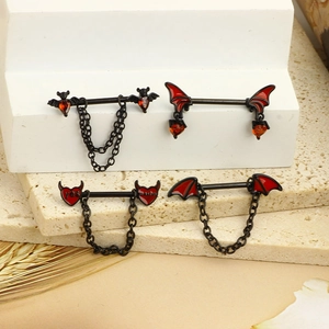 Gothic black steel nipple rings with red bat wings and heart charms on stone pedestals