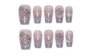 Macro detail of coffin shaped cat-eye press-on nails with silver butterfly and glitter