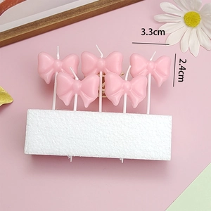 Detailed view of pink bowknot cake candles with dimensions for birthday party decor