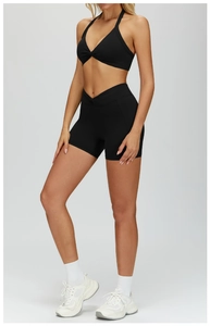 Detail of black twist-knot halter sports bra and high-waisted gym shorts set