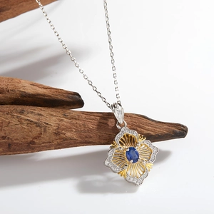 Detail of flower pendant necklace with blue gemstone and diamonds on a wooden stand