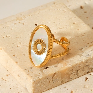 Vintage gold stainless steel sun ring with white shell inlay on stone background
