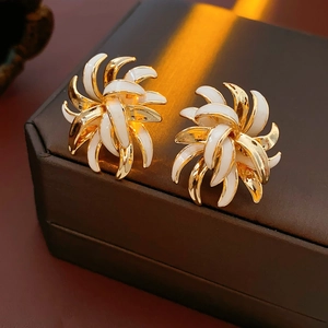 Detail of vintage flower stud earrings in gold-plated metal and white enamel petals