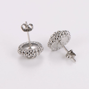 Detail of round full diamond earrings with butterfly backs on white background