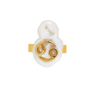 Macro detail of irregular baroque pearl ring with golden Cancer zodiac symbol