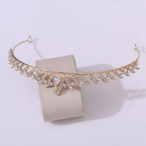 Macro detail of a golden bridal crown with sparkling zircons and water drop rhinestones