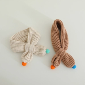Detail of ribbed knit children's scarves with colorful pom poms in cream and brown