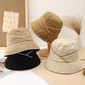 Close-up of four colors of cotton linen sun hats featuring stylish criss-cross ribbon details