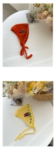 Detail of hand-knitted flower headbands with straps in orange and yellow soft wool fabric
