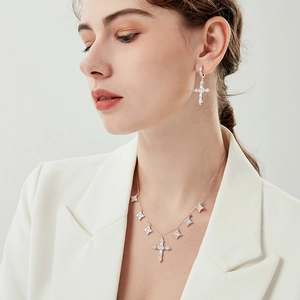 Elegant 925 silver cross pendant necklace and matching earrings set on a model