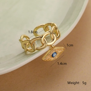 Macro shot of 18K gold plated evil eye chain ring with measurements on a green ceramic plate