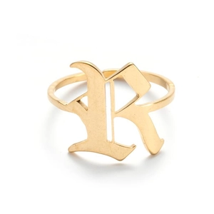 Macro shot of gold gothic letter R engraving on a vintage stainless steel open ring