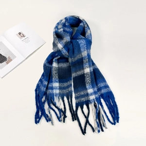 Detail view of the soft mohair texture and long tassel fringe on blue checkered scarf