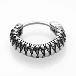 Macro shot of silver stainless steel earring with unique spiky textured fish scale design