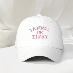 White cotton baseball cap with pink TANNED and TIPSY embroidery and curved brim