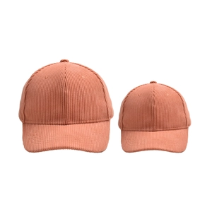 Close-up of orange corduroy baseball caps set for parent and child with fine texture