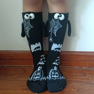 Detail of Halloween socks with 3D eyes, spider webs, and pumpkin patterns for couples