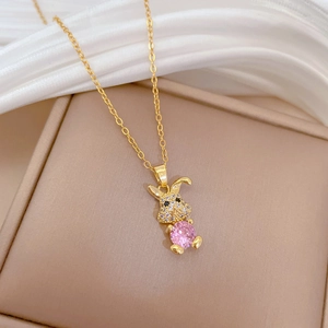 Close-up of a gold bunny necklace featuring a pink crystal and white pavé diamonds