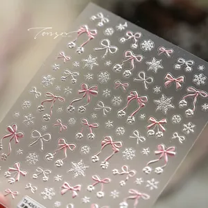 Detail shot of 3D embossed pink bows and white snowflake nail art stickers TS4263