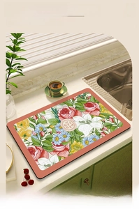 Macro shot of absorbent leather dish drying mat with vintage floral pattern on marble counter