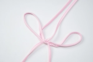 Detail shot of the pink drawstring knot on a slim fit halter top with glossy fabric