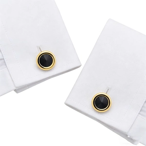 Classic round gold-rimmed cufflinks with black faceted crystals on a white shirt cuff