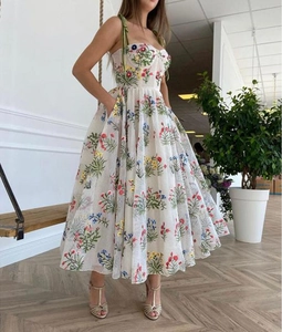 Detailansicht der bunten Blumenstickerei und des strukturierten Stoffes auf weißem Kleid