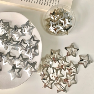Y2K silver star-shaped metal hair clips displayed in a white ceramic dish