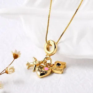 Detailweergave van de reishangers met vliegtuig, camera en hart op een gouden ketting