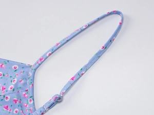 Détail de la bretelle florale réglable avec boucle en métal sur robe d'été bleu clair