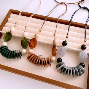 Detail of bohemian layered beaded necklaces with resin stones in a velvet jewelry tray