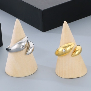 Detail of gold and silver plated open rings with dolphin droplet design and small diamond