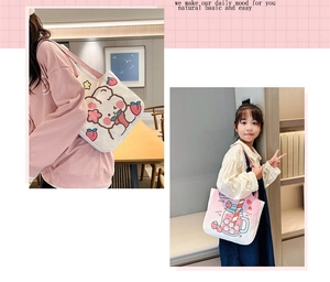 Detail view of pink and white canvas tote bags with cute strawberry rabbit illustrations