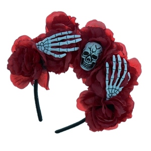 Detail of Halloween headband with red roses, plastic skull and skeletal hand accents