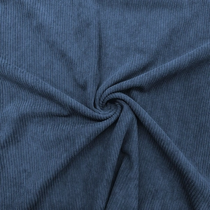 Detailed texture of dark blue ribbed knit fabric showing soft draped material quality