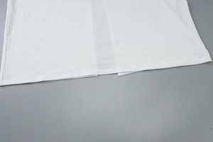 Detailed close-up of the white dress hem stitching and high-quality cotton fabric texture