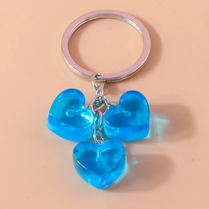 Detail of three translucent blue jelly heart pendants on a silver metal keychain ring
